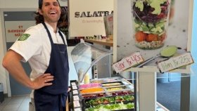 Salatbar med mye farger og en smilende kantinemann.