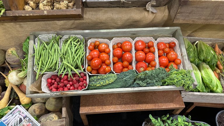 Bilde viser ulike økologiske grønnsaker i en trekasse.